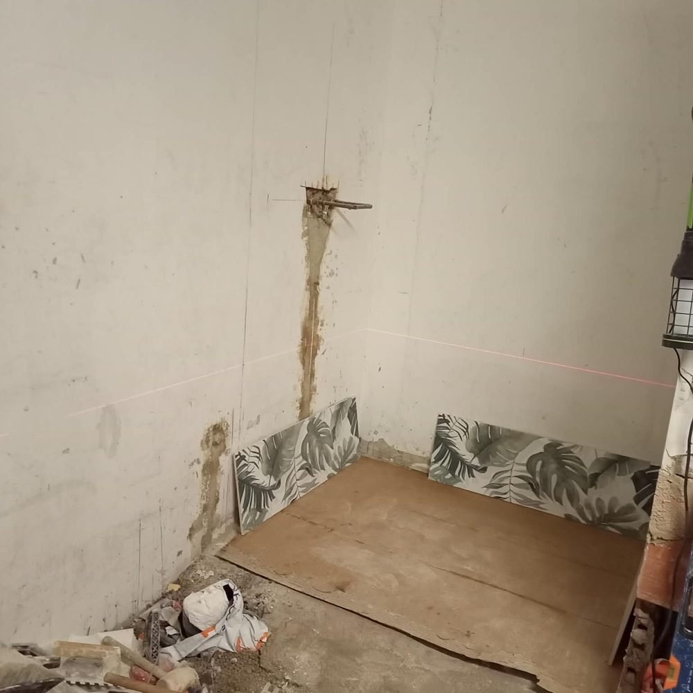 Baño en obras, con las paredes picadas y el suelo levantado