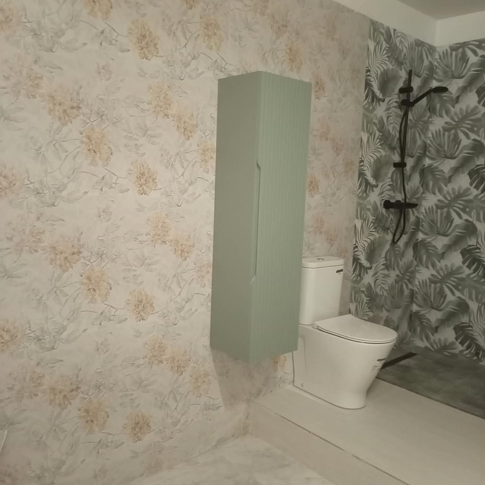 El mismo baño acabado, alicatado con motivo vegetal, ducha y mueble