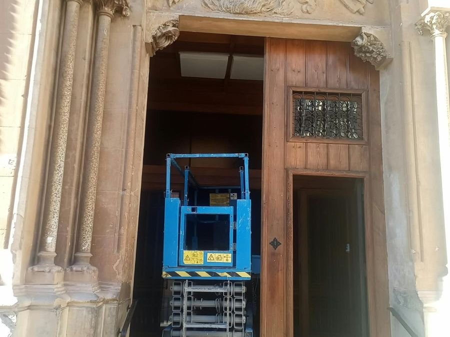 Plataforma de tijera en la puerta de una iglesia durante un trabajo de mantenimiento